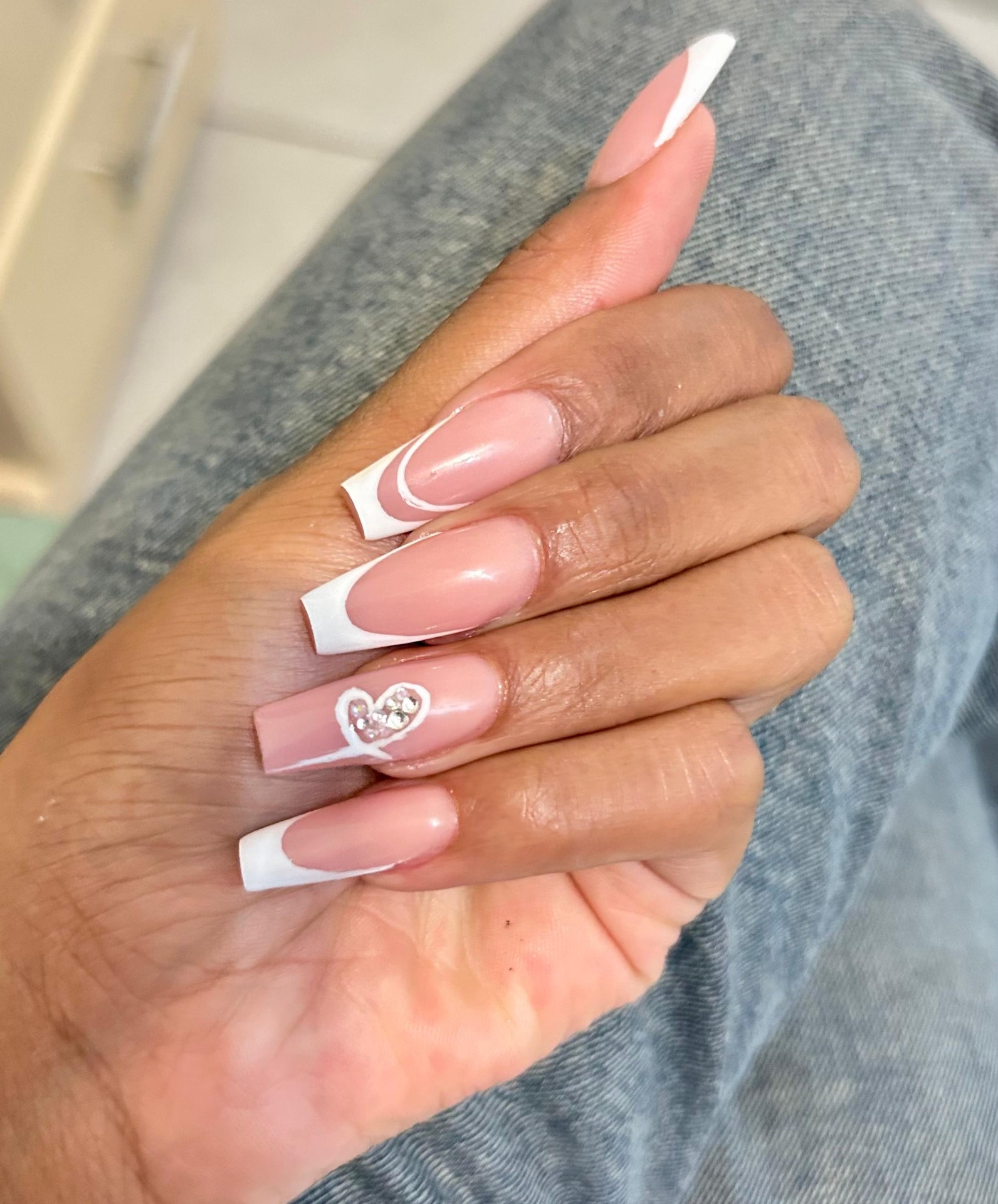 Beautiful French tip nail set with heart accent by Monica's Nail & Beauty Bar