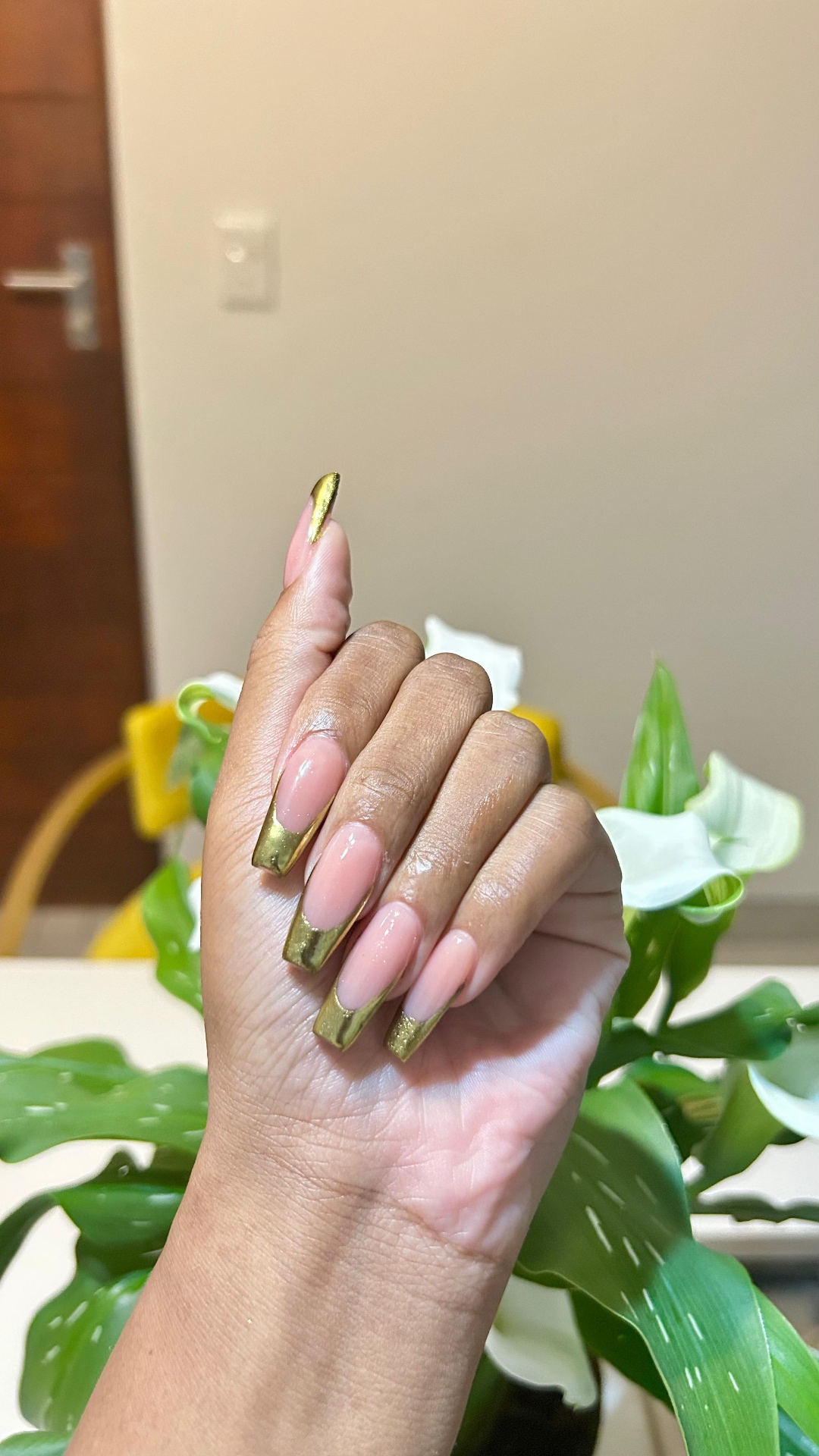 Nude nails with glossy gold chrome French tips